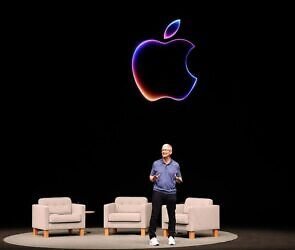An image of a man on a stage with Apple symbol behind him.